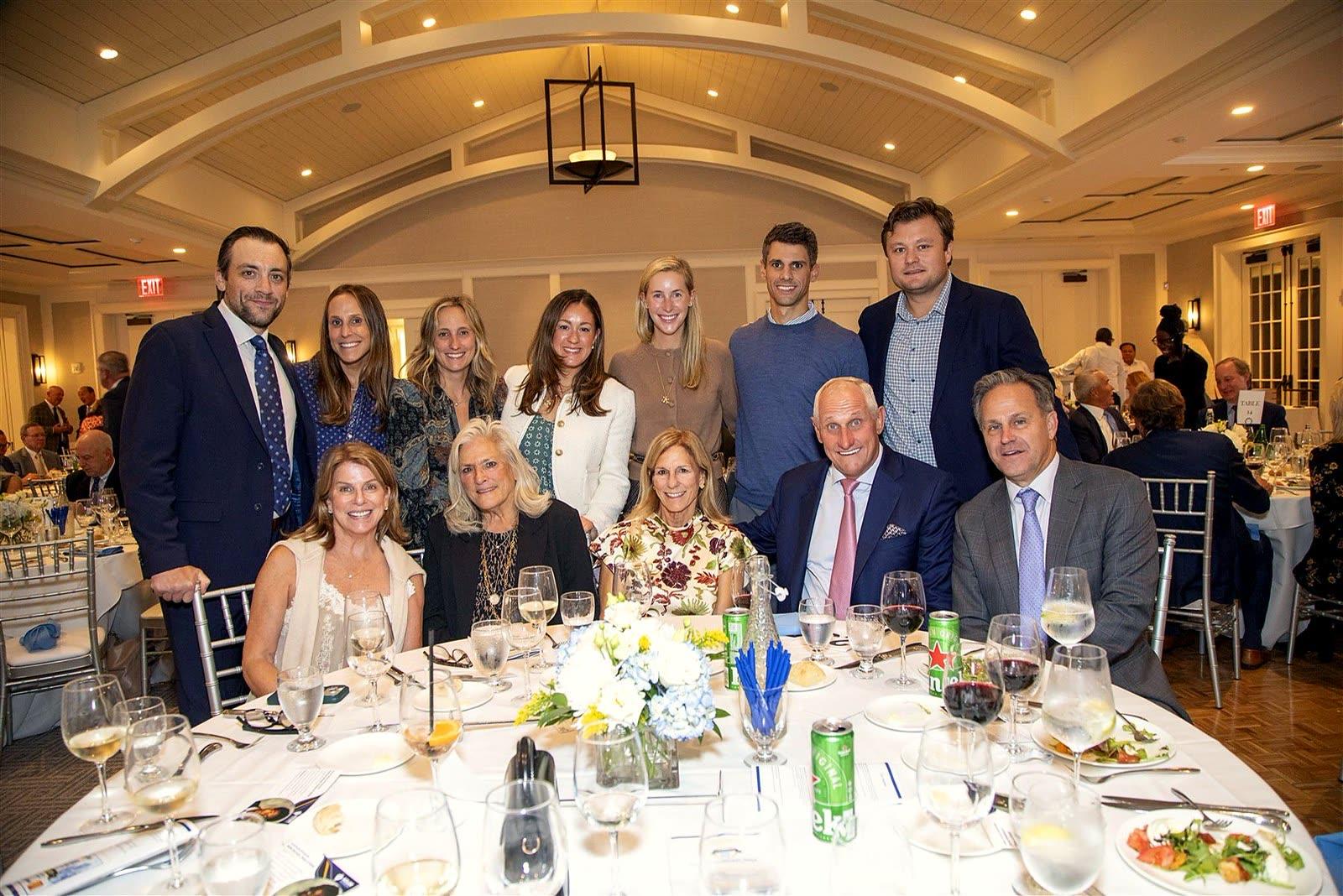 A table of guests posing together during dinner.